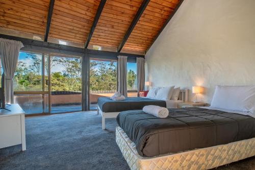 two beds in a room with windows at Cozy Family Life Style Villa in Riverhead