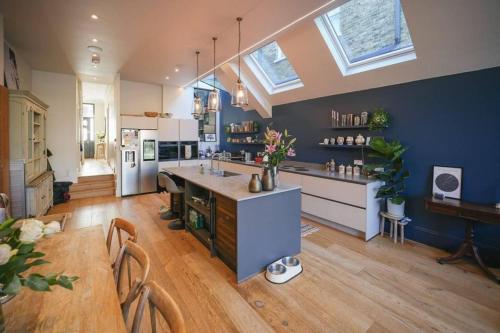 a large kitchen with blue walls and a wooden floor at Stunning Modern 5-Bed House in Central London in London