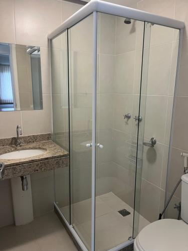 une douche en verre avec un lavabo et des toilettes dans l'établissement Apartamento Rio Marina Resort, à Mangaratiba