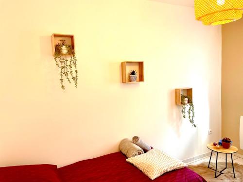 uma sala de estar com um sofá vermelho contra uma parede branca em Appart proche stade de France em La Courneuve
