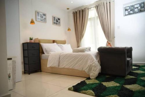 een slaapkamer met een bed, een stoel en een raam bij Luxury Suite 42m2 @ Embassy Gardens Cantonments in Cantonments