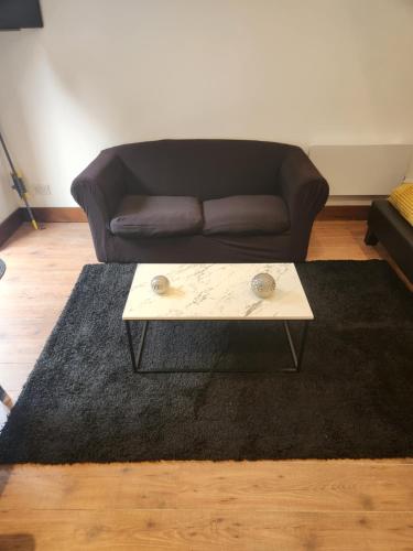 a living room with a couch and a coffee table at Cosy Studio Flat in Bexleyheath