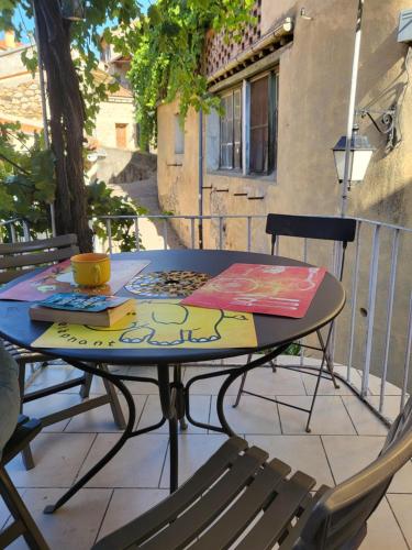 - une table avec un tableau sur la terrasse dans l'établissement Little Pink House, à Vernet-les-Bains