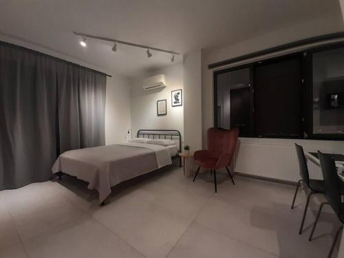 伊古邁尼察的住宿－Μοντέρνο Στούντιο, με Θέα，卧室配有床、椅子和窗户。
