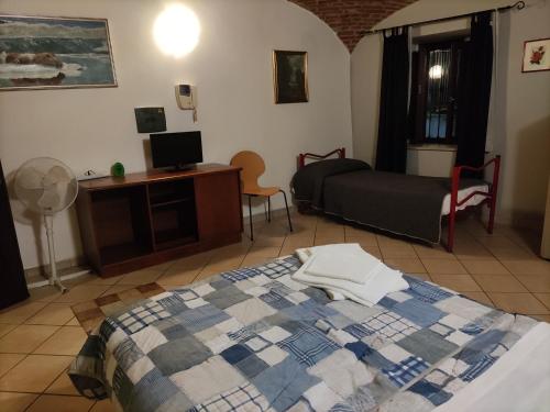 a bedroom with a bed and a desk and a tv at Hotel PALAS in Bruzolo