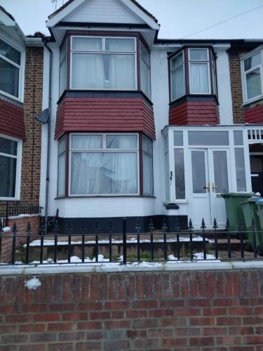 a house with a black fence in front of it at Room from home in Abbey Wood