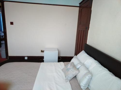 a bedroom with a bed with white sheets and pillows at Room from home in Abbey Wood