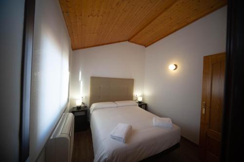 a bedroom with two white beds and a wooden ceiling at Apartamento Santa Bárbara in Castilleja de la Cuesta