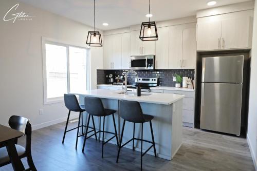 a kitchen with a large island with bar stools at Beautiful 3 King Beds,Garage,Airport,Disney+ in Edmonton