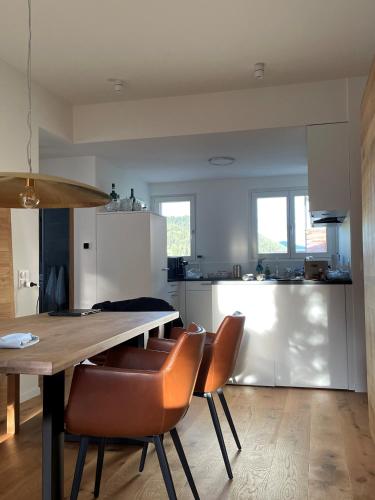 a kitchen with a wooden table and leather chairs at Sonnendurchflutete Familienwohnung in Platta