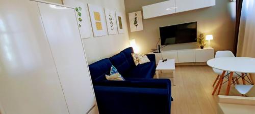 綠山城的住宿－Drzewna Apartamenty - Niepodległości，客厅配有蓝色椅子和桌子