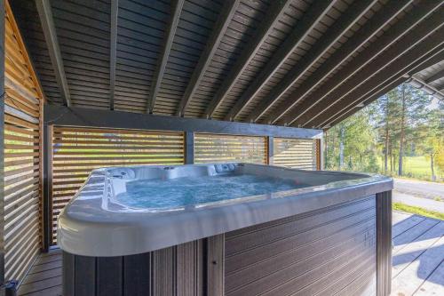 a large hot tub in a wooden building at Luksushuvila Villa Marvik in Himos