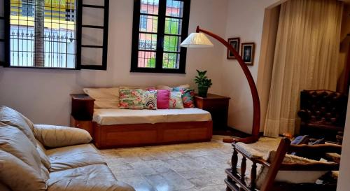 a living room with a bed and a couch at Casa em mangaratiba in Mangaratiba