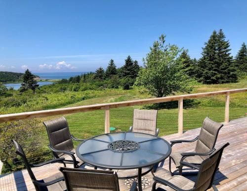 a patio with a table and chairs on a deck at Colindale Beach Villas in Port Hood