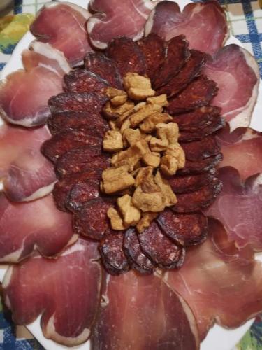 a plate with a bunch of grapes and bacon at Apartments Bakine Čarolije in Karanac
