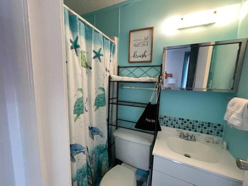 uma casa de banho com um WC, um lavatório e um espelho. em Gulf Shores Getaway steps away from the pool! em Gulf Shores