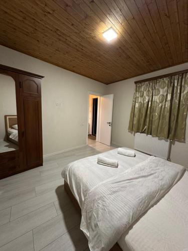 a bedroom with a large bed and a wooden ceiling at Private apartment in Tbilisi City