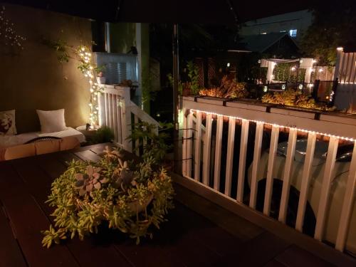 a porch with a white fence and lights at Tranquility at the House of Alchemy Hollywood in Los Angeles