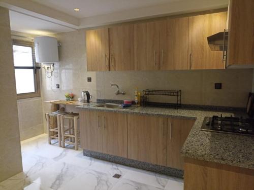 a kitchen with wooden cabinets and a counter top at Appartement luxueux proche de tout in Fès