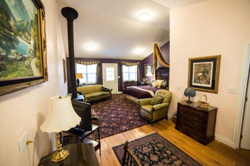 uma sala de estar com uma cama e um sofá em Hearthstone Elegant Lodge em Kamiah