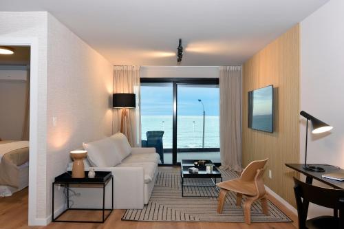 uma sala de estar com um sofá branco e uma mesa em Vistas al Mar en Exclusivo Apartamento con Garage em Montevidéu
