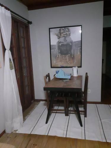 a dining room with a table and a picture on the wall at Chalé ensolarado in Lages