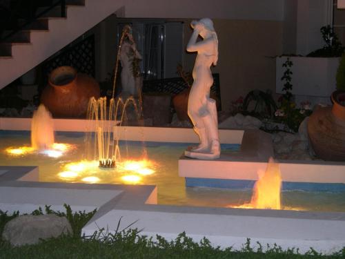 a statue of a woman in a fountain with lights at Paradise Hotel in Samos