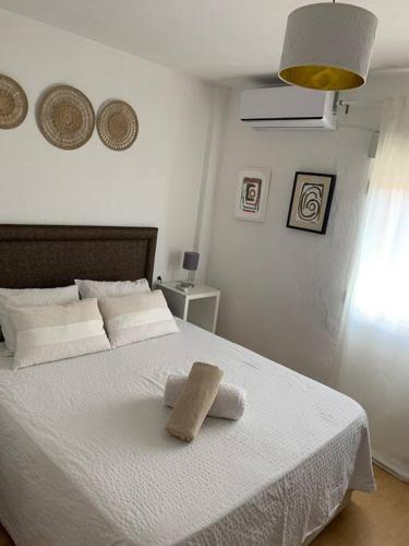 a bedroom with a white bed with a towel on it at Harmony room málaga piso compartido in Málaga