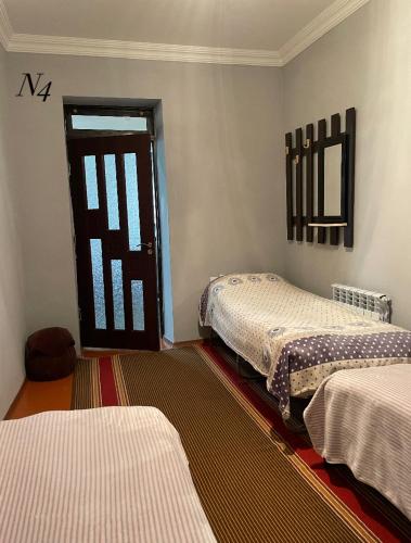 a room with two beds and a door in a room at Emma B&B in Tatʼev