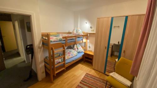 een kleine kamer met een stapelbed en een spiegel bij Appartement Schareckblick in Bad Gastein