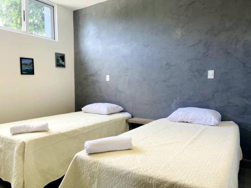 um quarto com duas camas com lençóis brancos em Condominios Akira em Tamarindo