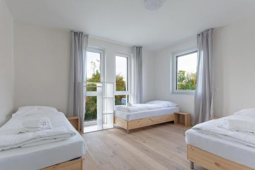 a bedroom with two beds and two windows at T&K Apartments - Bergisch Gladbach - 7 Comfortable Apartments - 20 min to Fair Messe Cologne in Bergisch Gladbach