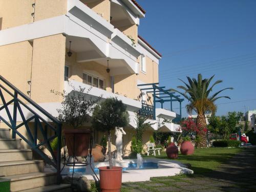 a building with stairs and potted plants in front of it at Paradise Hotel in Samos