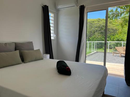 a bedroom with a bed with a hat on it at Bienvenue à la Villa Ifè in Le Gosier