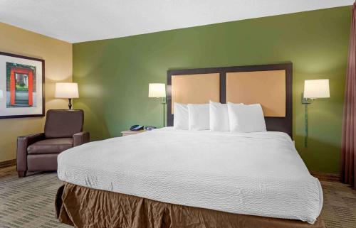 a hotel room with a large bed and a chair at Extended Stay America Suites - Houston - Galleria - Uptown in Houston