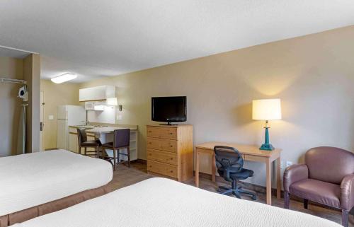 Habitación de hotel con cama, escritorio y TV. en Extended Stay America Suites - Houston - Galleria - Uptown en Houston
