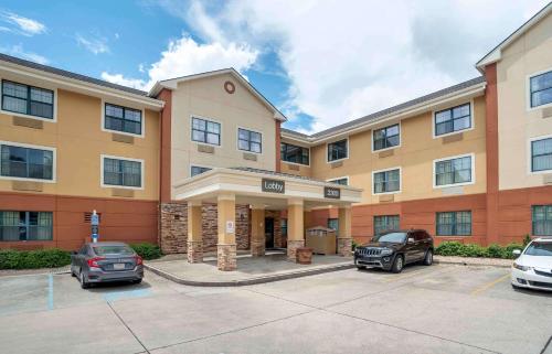 a hotel with two cars parked in a parking lot at Extended Stay America Select Suites - New Orleans - Airport in Kenner