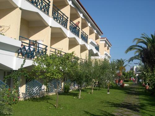 a building with a yard with trees next to it at Paradise Hotel in Samos