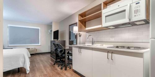 a kitchen with white cabinets and a table and a dining room at Extended Stay America Premier Suites - San Francisco - Belmont in Belmont