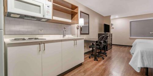 a kitchen with white cabinets and a table in a room at Extended Stay America Premier Suites - San Francisco - Belmont in Belmont