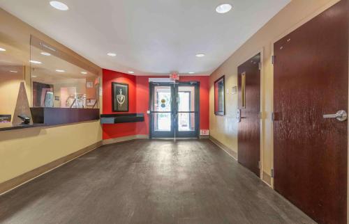 an empty hallway with red walls and a door at Extended Stay America Suites - San Jose - Edenvale - North in San Jose