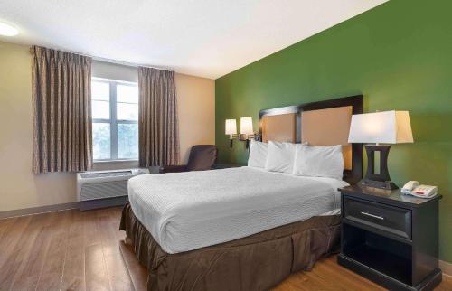 a hotel room with a bed and a green wall at Extended Stay America Suites - San Jose - Edenvale - North in San Jose
