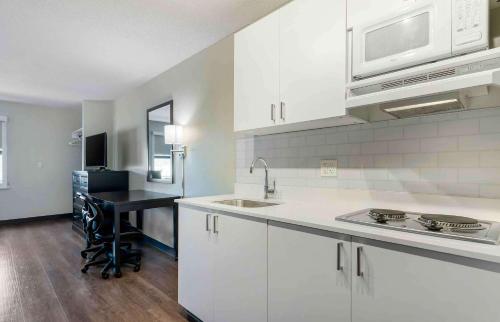 a kitchen with white cabinets and a sink and a microwave at Extended Stay America Suites - San Ramon - Bishop Ranch - East in San Ramon