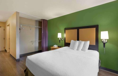 a bedroom with a white bed and a green wall at Extended Stay America Suites - Cleveland - Airport - North Olmsted in North Olmsted