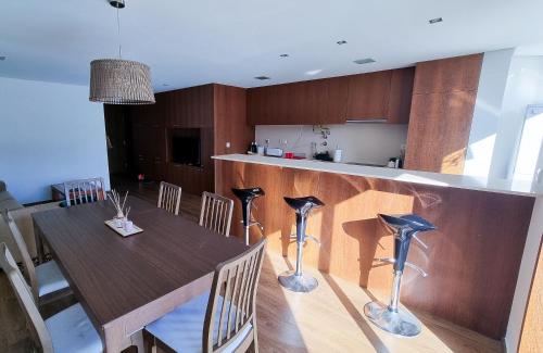 a kitchen and dining room with a wooden table and chairs at Apartament F&M in Braga