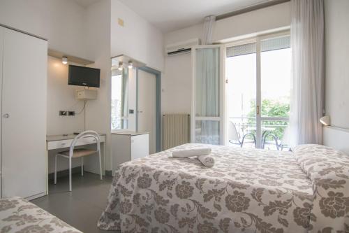 チェゼナーティコにあるB&B Hotel Souvenirのベッドルーム1室(ベッド1台、デスク、窓付)