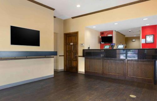 a hotel room with a bar and a flat screen tv at Extended Stay America Select Suites - Phoenix - Airport - E Oak St in Phoenix