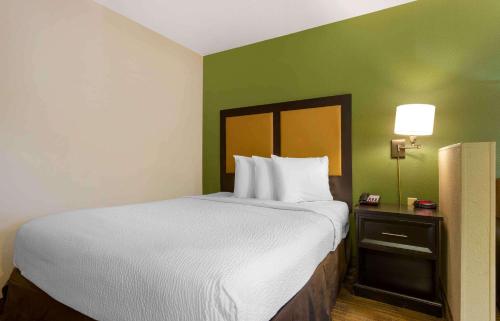 a large bed in a room with a green wall at Extended Stay America Select Suites - Phoenix - Airport - E Oak St in Phoenix