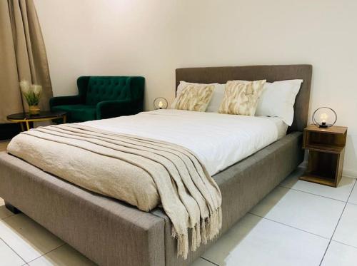 a bedroom with a large bed with a blanket on it at Yolé Apartment - City 101 in Windhoek
