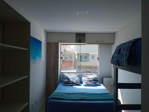 a small bedroom with a bunk bed and a window at Sobrado Carpe Diem Palmeiras, 450 m da praia, 2 suítes com ar, 2 vagas, check-in 24h, churrasqueira, 20 min do Beto Carrero in Piçarras